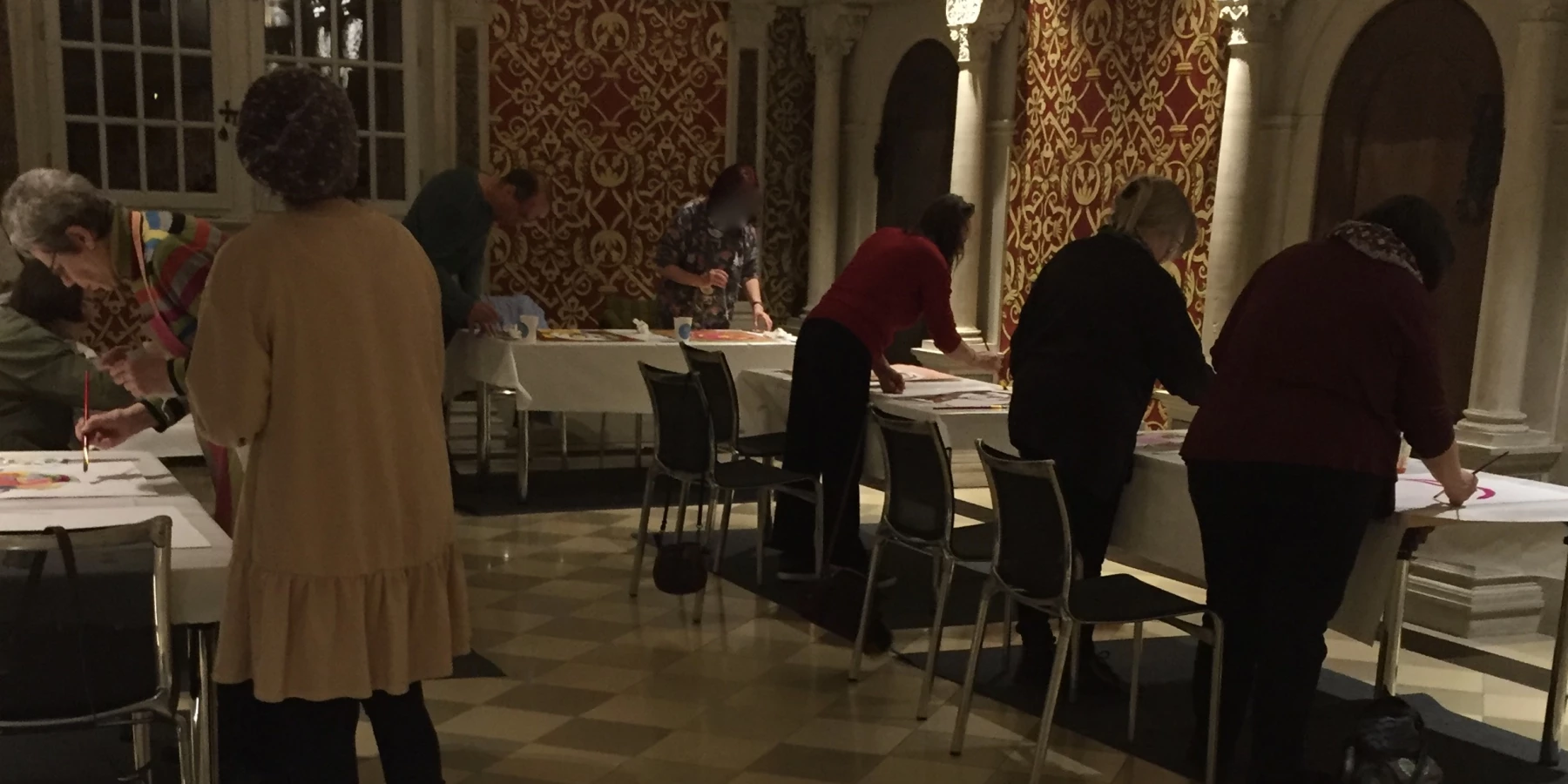 Erwachsene malen in einem beeindruckenden Raum mit Kapitälen