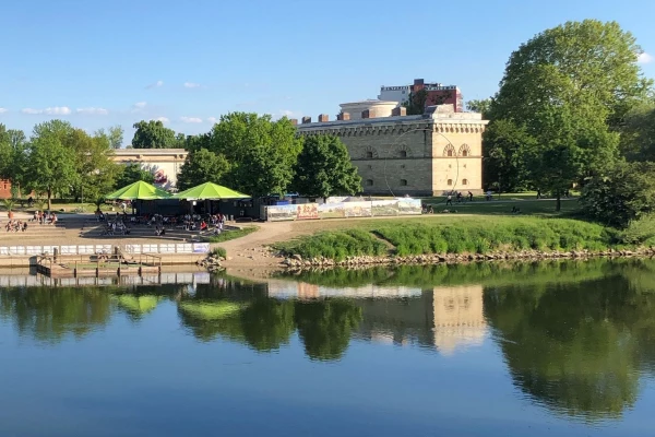 Ein Gebäude spiegelt sich im Wasser der Donau