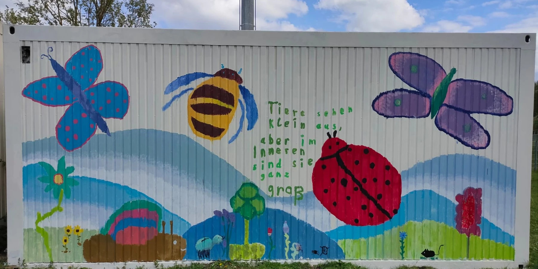 Ein bunter, mit Insekten und Blumen bemalter Container
