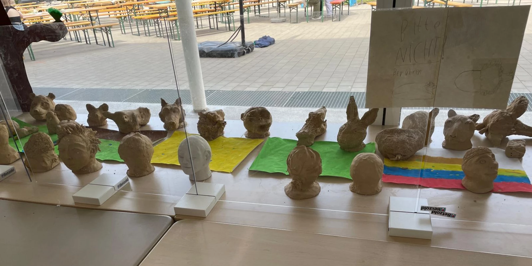 Von Kindern gestaltete Tier- und Menschenköpfe aus Ton