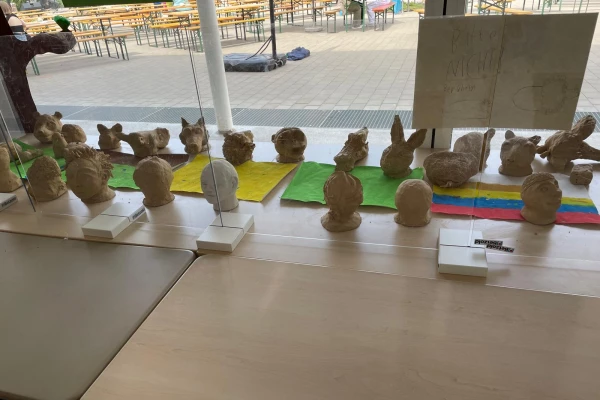 Von Kindern gestaltete Tier- und Menschenköpfe aus Ton