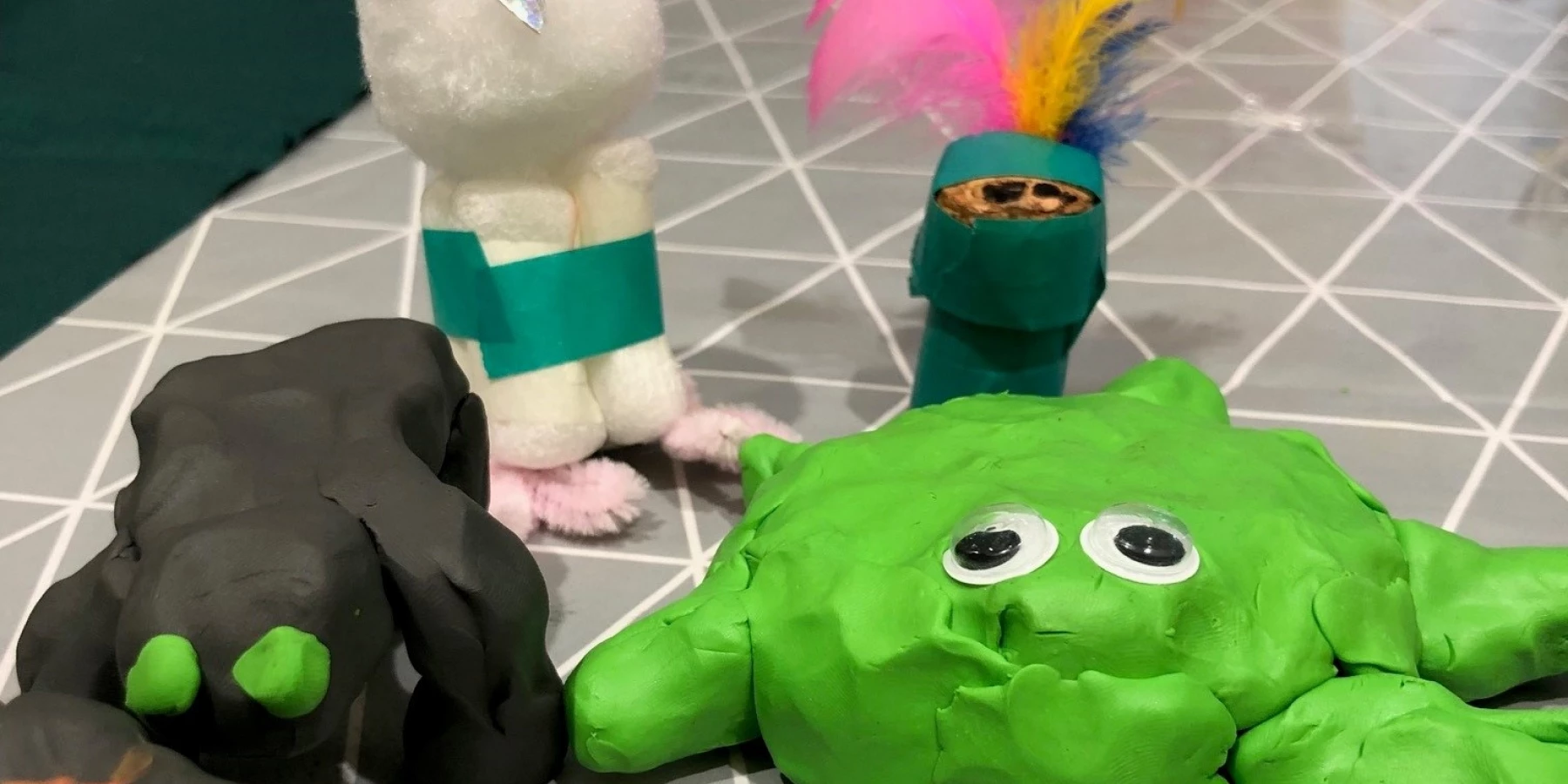 Bunte Tierfantasiefiguren, z.T. aus Knetmasse und Federn
