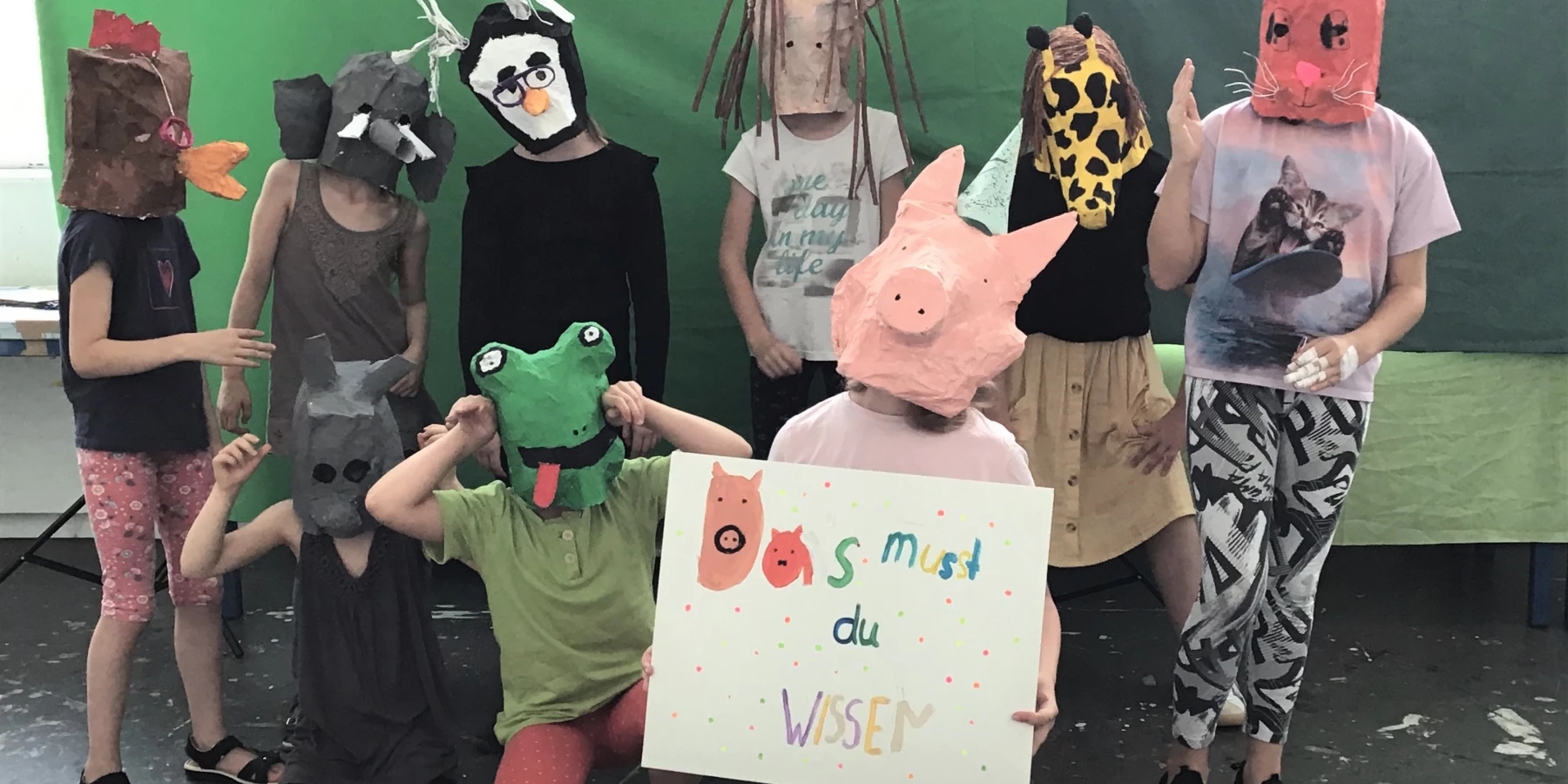 Kinder tragen Tierköpfe aus Pappmaché, Karton und Papier