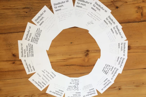 Flyer liegen aufgefächert in einem Kreis. Oben auf jedem steht 