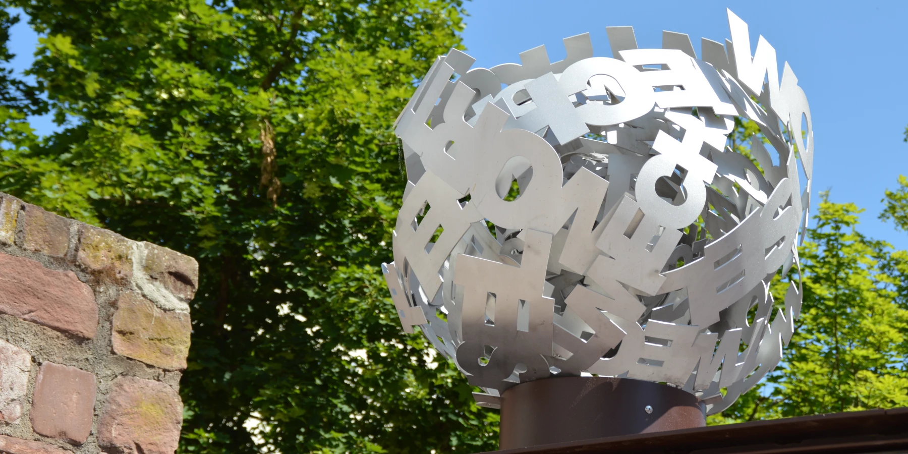 Eine öffentliche Skulptur: gebogene Metallworte bilden einen Knäuel
