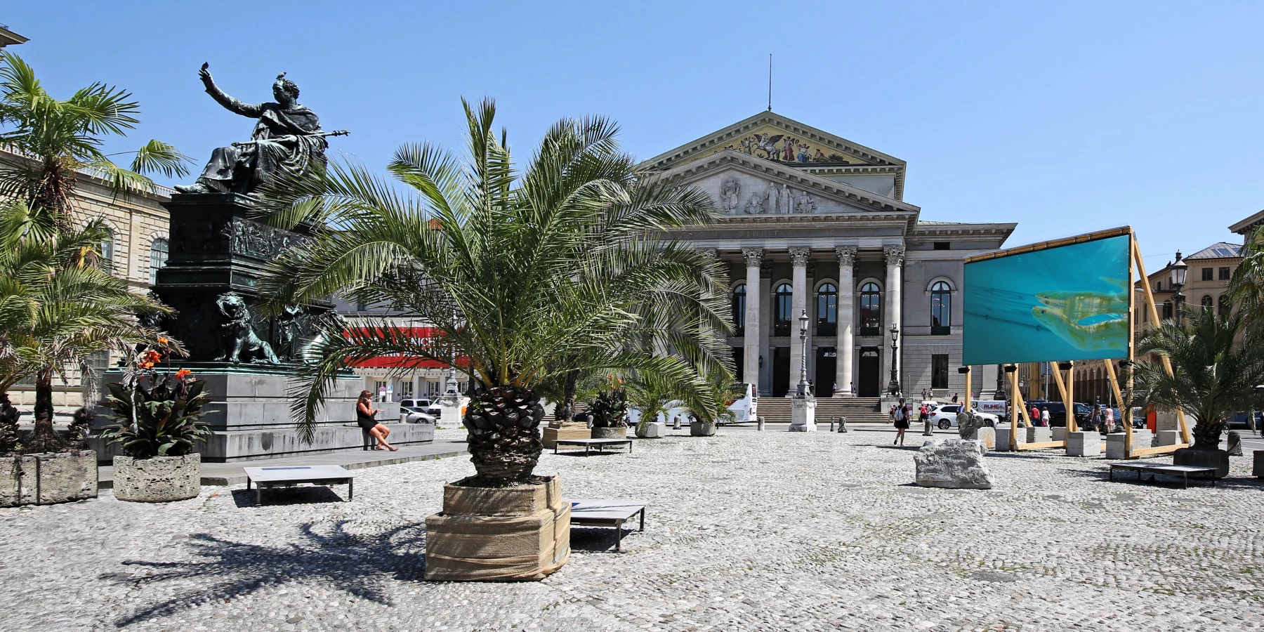 Am Max-Joseph-Platz sind vor der Oper große Palmen aufgestellt